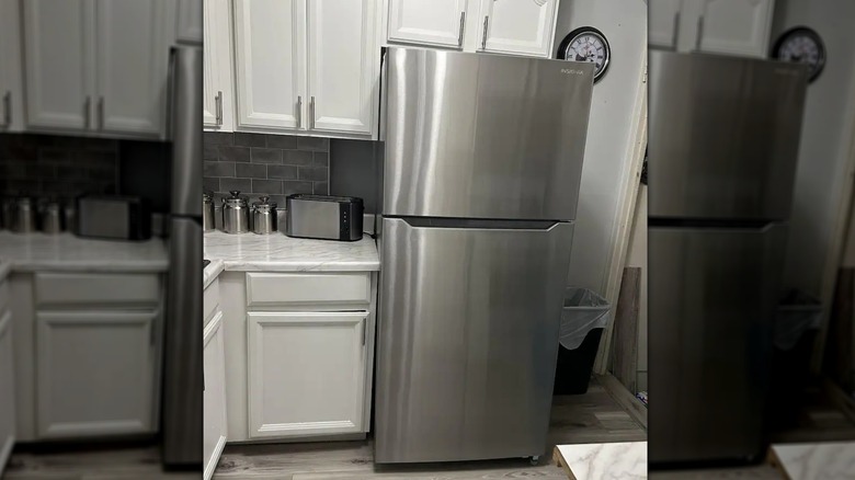 Stainless steel Insignia refrigerator with minimalist and seamless exterior in classic white kitchen