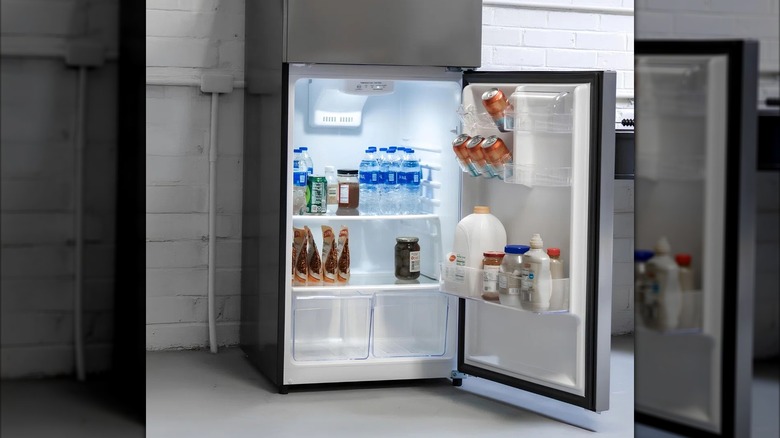 Open Magic Chef fridge stocked with drinks and essentials