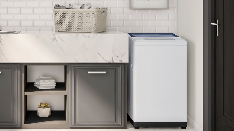 Magic Chef portable washer next to laundry basket