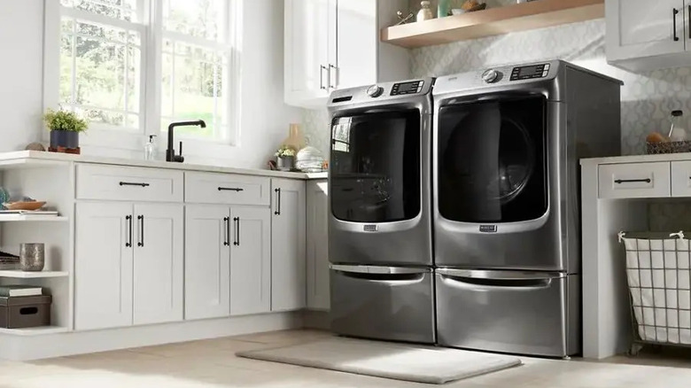 Maytag washing machine beside dryer in stylish room