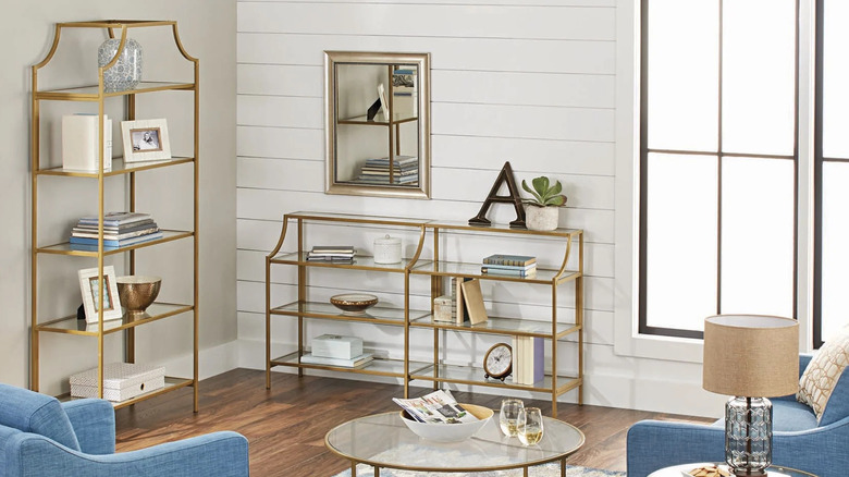 Several gold-finished furniture pieces from the Better Homes & Gardens Nola collection are arranged in a light-filled living room