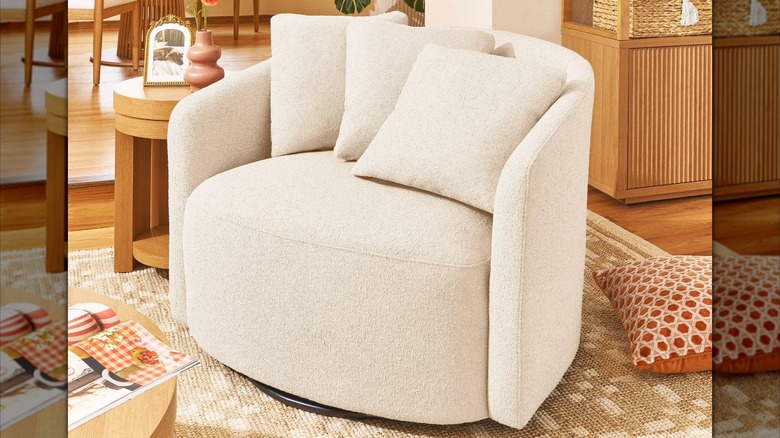 A cream-colored bouclé accent chair sits in a warm living room