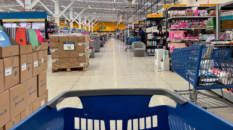 A blue shopping cart is pushed through the furniture aisle at Walmart