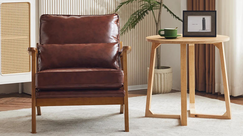 A leather armchair sits next to a light wooden side table