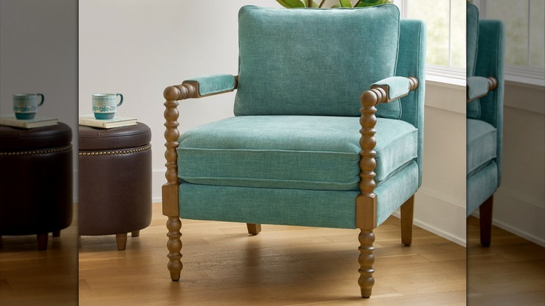 A jade-colored spindle accent chair sits in front of a window