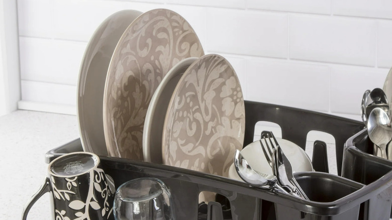 Dishes, silverware, and mugs dry in a black Sterilite DrainRack