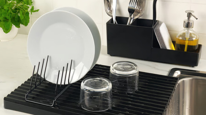 Black IKEA plate holder alongside other IKEA dish and kitchen storage solutions beside sink