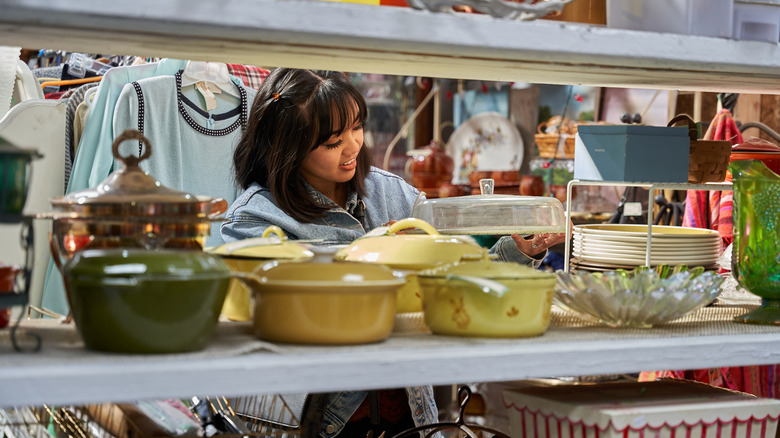 someone shopping for dishware at the thrift store