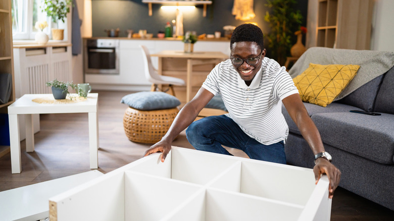 Man assembling new white dresser.