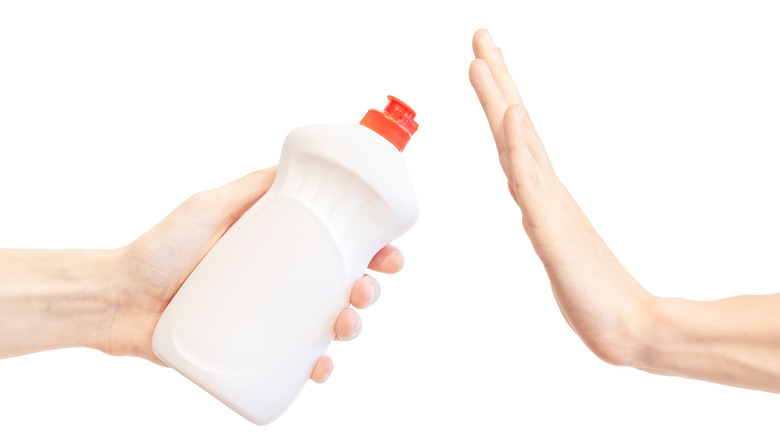 Persons hand refusing dishwashing detergent