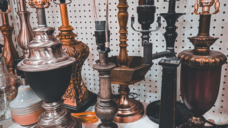 Various lamps on a shelf at a thrift store