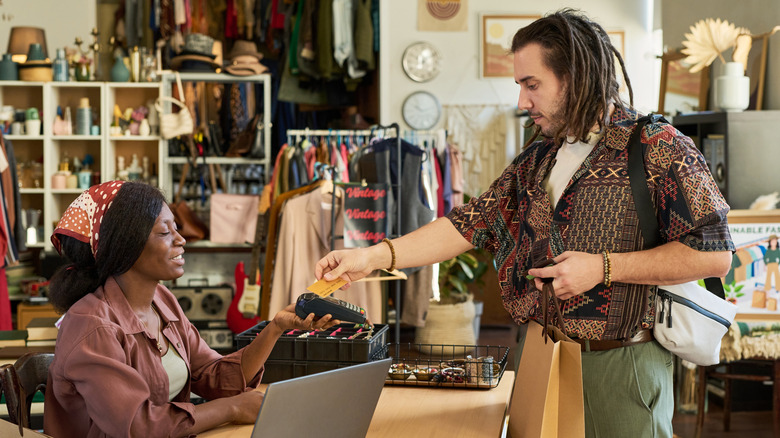 Man with a bag in his hand checking out at a thrift store