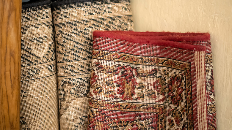 Rolled-up rugs with the backing showing