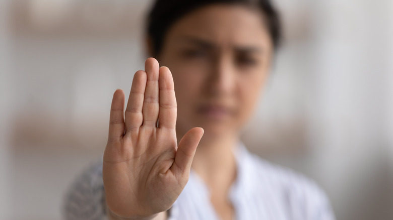 woman holding hand up to stop