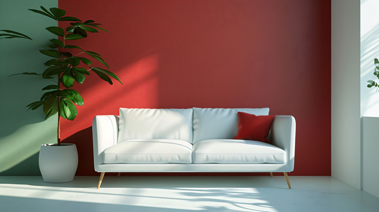 Red accent wall behind a white sofa