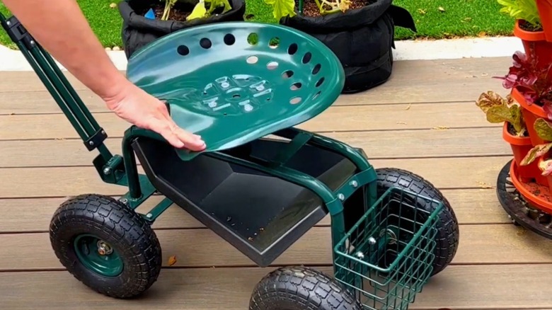 Person adjusting the seat on Vevor rolling garden cart