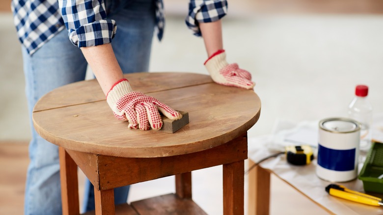 person refurbishing wooden table
