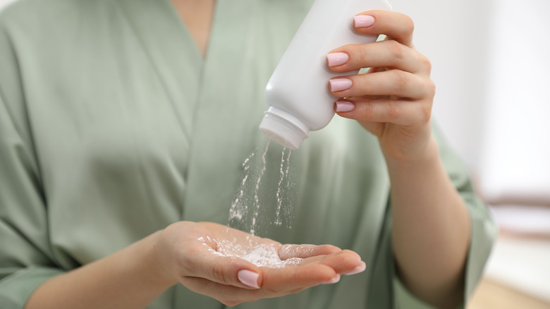 Close up of a person pouring out talcum powder into a hand