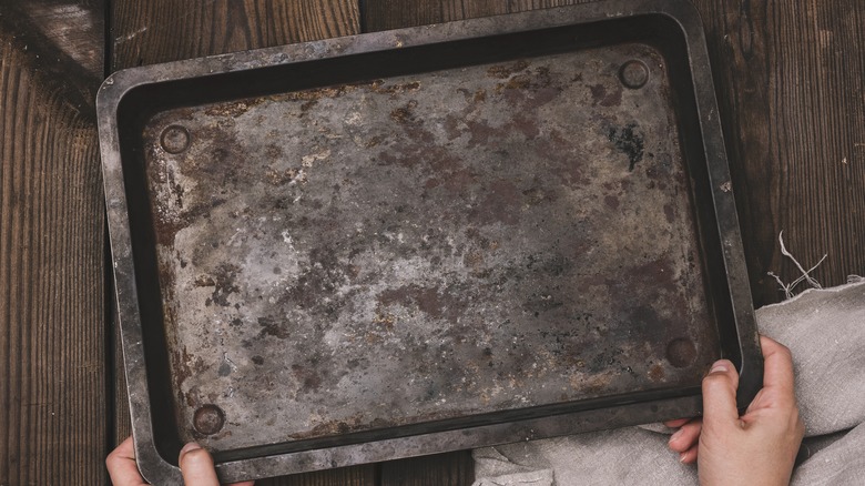 holding old baking tray 