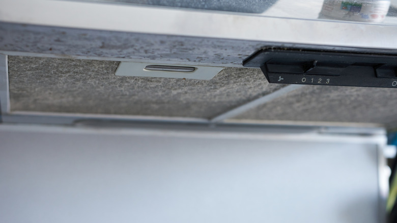 A stove range hood is covered in dirt
