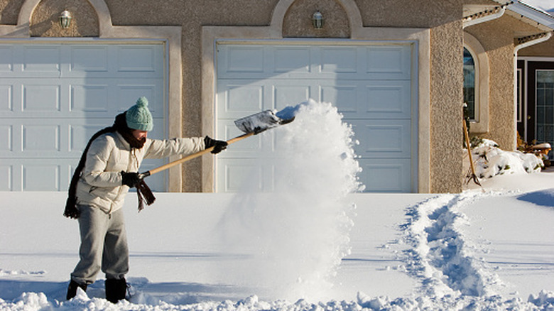 Woman shoveling driveway