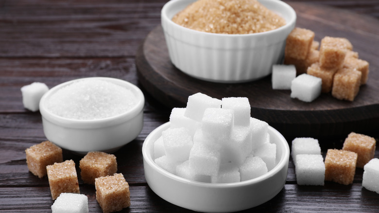 Different types of sugar on a wooden tabletop.