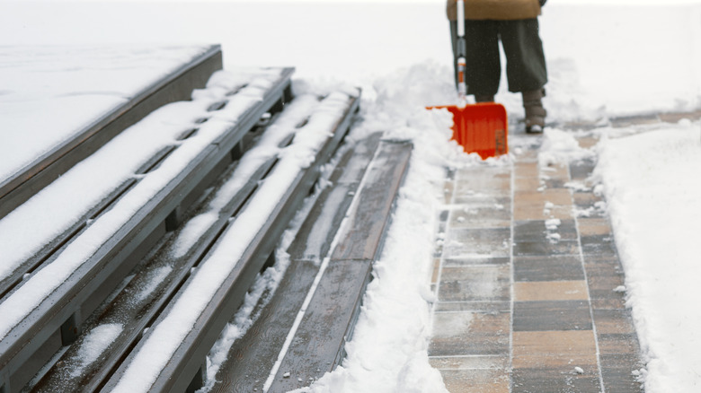 Person shoveling snow away from steps