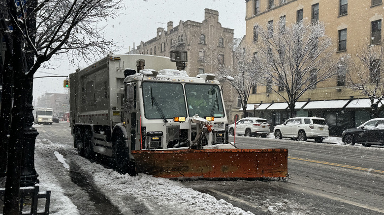 Snow plow driving through city streets