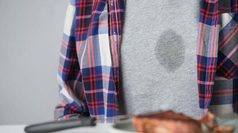 Person with grease stain in center of shirt
