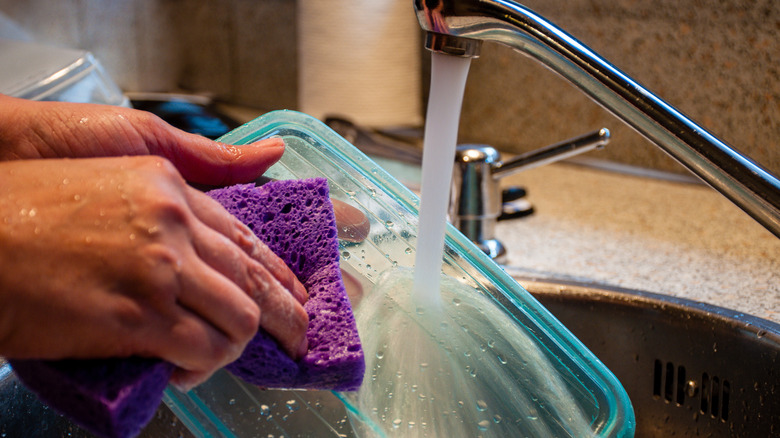 woman washes plastic container