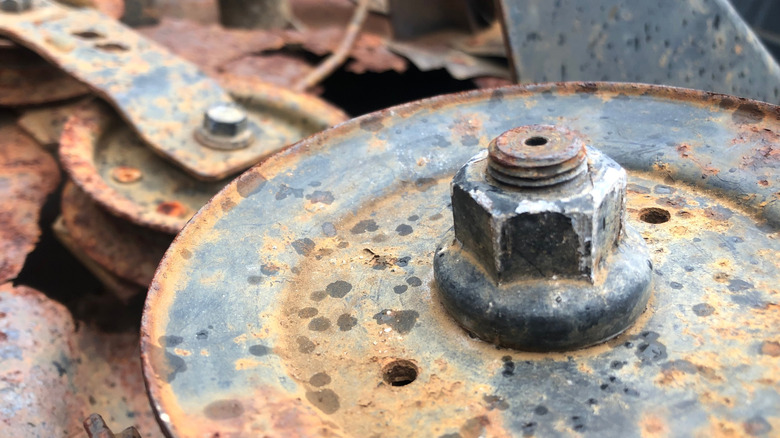 A damaged and rusty bolt on an engine