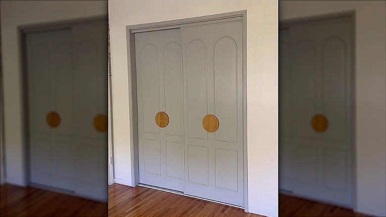 Vinyl covered closet doors painted gray with bold, round wooden handles