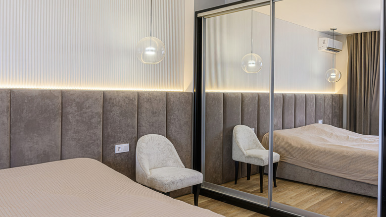 Large mirrored closet doors reflect a modern bedroom
