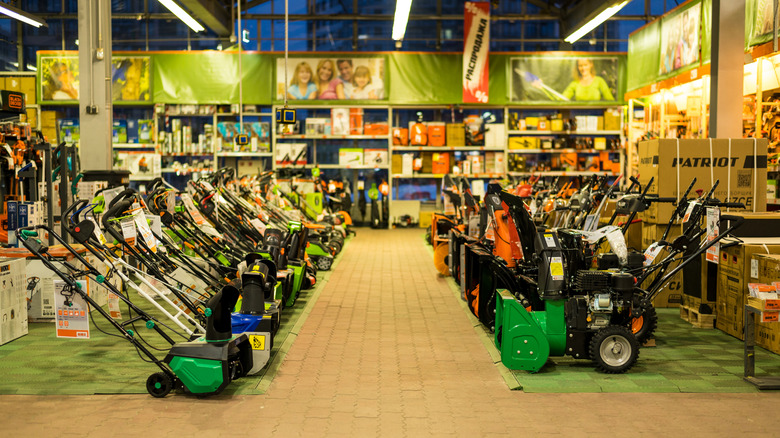 Snow blowers lined in two rows in a store