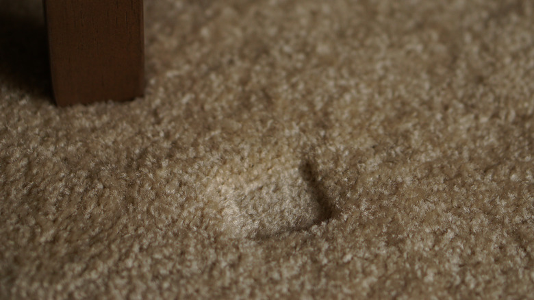 Dent in brown carpet