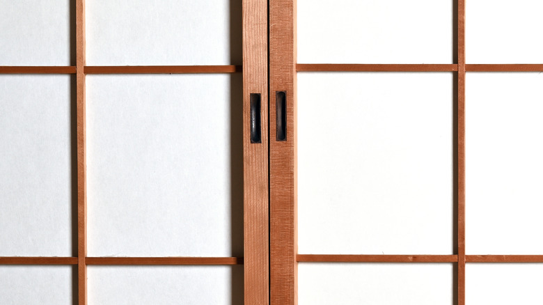 A brown wood and white paper Shoji-style closet door.