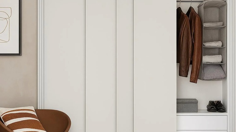 White sliding vertical blinds slightly open in front of a closet.