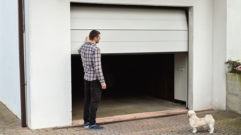 Man and dog looking at garage roller door