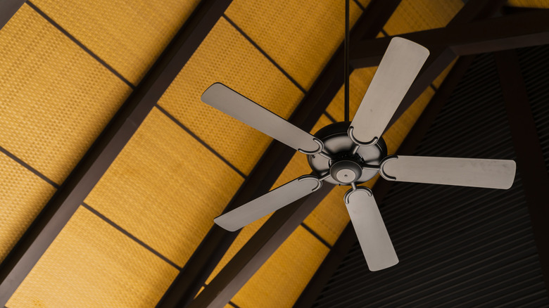 A ceiling fan hanging from rafters.