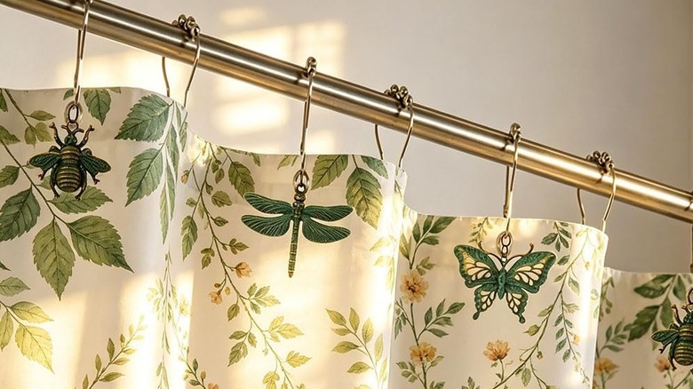 Nature-inspired shower curtain rings with bee, dragonfly, butterfly pendants.