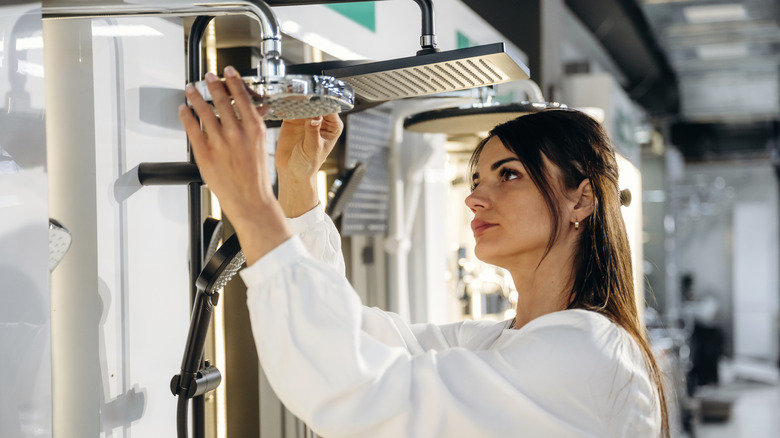 Woman inspecting a new showerhead at a showroom
