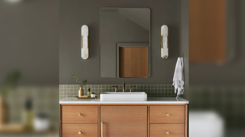 Bathroom vanity in olive green square tile with grayish-brown painted upper wall.