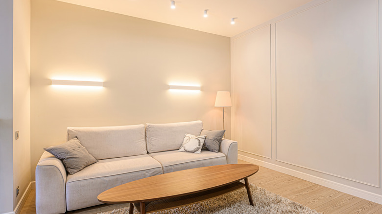 Room painted in a parchment white tone with cream colored sofa and wood coffee table