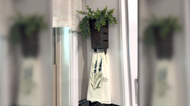 a box grater repurposed as a towel holder