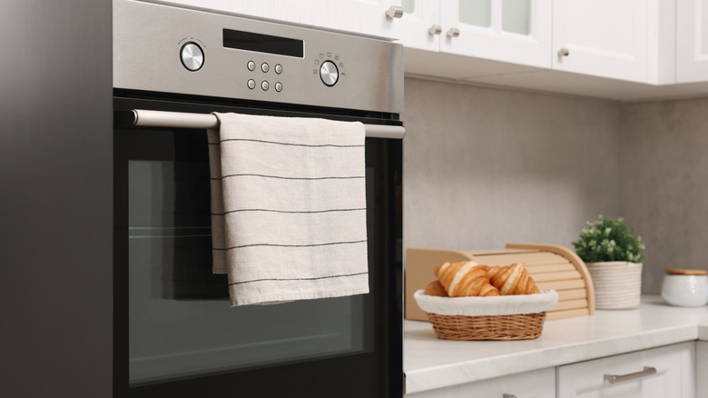 An oven with a striped dish hanging over its handle