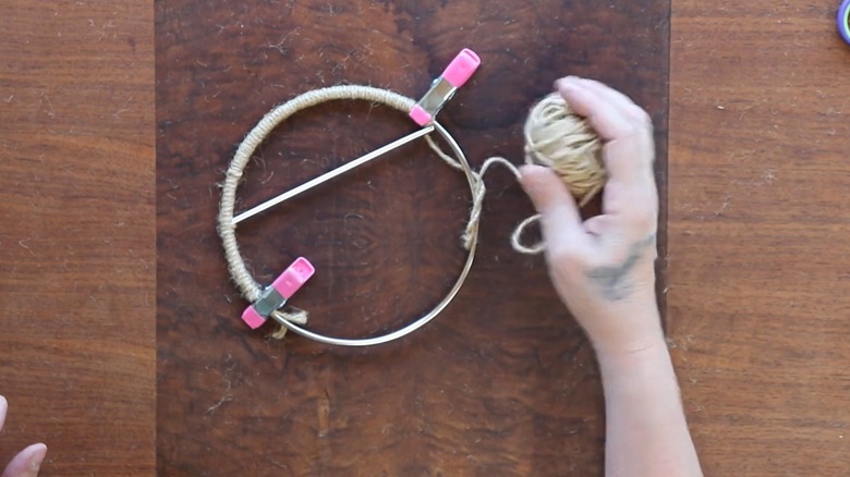 Person making a DIY humming bird swing using macrame hanger and twine.