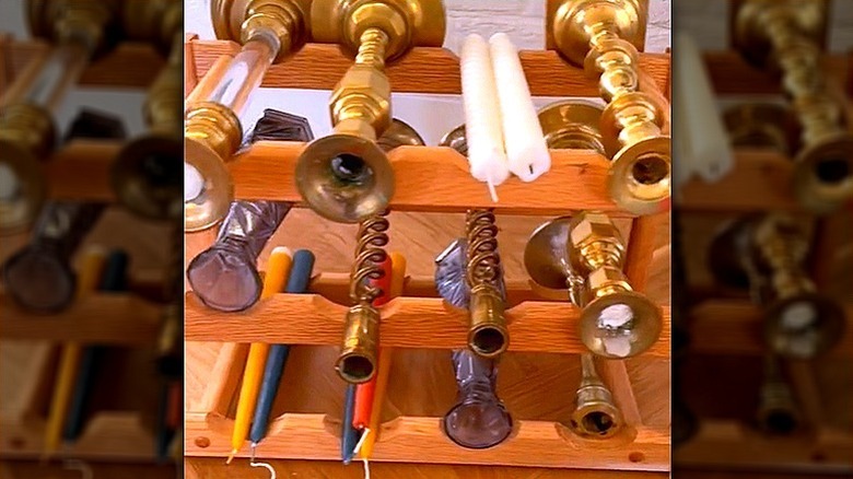 A wine rack repurposed as a candlestick organizer