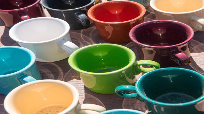 A group of ceramic coffee cups with colorful glazes.