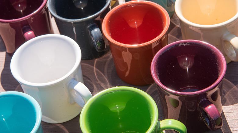 A group of ceramic coffee cups with colorful glazes.