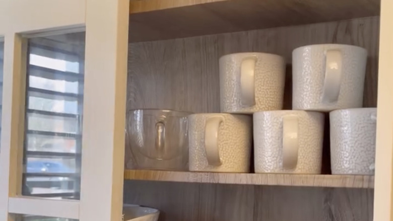 An old CD rack houses coffee mugs